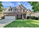 Charming two-story brick home featuring a two-car garage, manicured lawn, and classic architectural details at 106 Little Barley Ln, Grayson, GA 30017