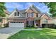 Charming two-story brick home featuring a two-car garage, manicured lawn, and classic architectural details at 106 Little Barley Ln, Grayson, GA 30017