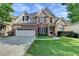 Charming two-story brick home featuring a two-car garage, manicured lawn, and classic architectural details at 106 Little Barley Ln, Grayson, GA 30017