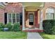 Close-up of a front door with a small porch, columns, and brick surround, accented by greenery at 106 Little Barley Ln, Grayson, GA 30017