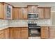 Close-up of kitchen with granite countertops, stainless steel appliances, and wood cabinets at 106 Little Barley Ln, Grayson, GA 30017