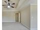 Spacious main bedroom with tray ceiling and ceiling fan features neutral paint, carpet and adjoins en suite bathroom at 106 Little Barley Ln, Grayson, GA 30017