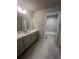 Bright bathroom featuring white vanity, tile floors, and marble tiled shower at 274 Lakeside Pl, Canton, GA 30114