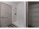 Bathroom with walk-in shower, white tile surround and brushed nickel fixtures, alongside door and shelving at 325 Forkview Dr, Lawrenceville, GA 30044