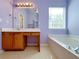Well-lit bathroom with vanity, soaking tub, tile floors and a neutral color scheme at 1421 Gates Se Cir, Atlanta, GA 30316