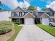 Two-story townhome with brick accents, a front lawn, and an attached garage at 1421 Gates Se Cir, Atlanta, GA 30316