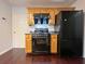 Functional kitchen area with black appliances, wood cabinets, and dark countertops at 1421 Gates Se Cir, Atlanta, GA 30316