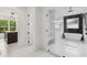 Bright bathroom featuring a glass-enclosed shower, soaking tub, and stylish fixtures at 1255 E M Croy Rd, Sugar Hill, GA 30518