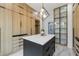 Luxurious closet features custom wood cabinets, an island with a white countertop, and stylish light fixture at 1255 E M Croy Rd, Sugar Hill, GA 30518