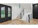 Bright entryway features hardwood floors, a staircase with black and glass railings, and a modern glass door at 1255 E M Croy Rd, Sugar Hill, GA 30518