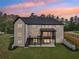 Rear exterior view of home showing lush lawn, deck, brick facade, and beautiful backyard at 1255 E M Croy Rd, Sugar Hill, GA 30518