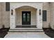 Grand front entrance featuring a double door, brick archway, and stylish wall sconces at 1255 E M Croy Rd, Sugar Hill, GA 30518