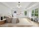 A bright primary bedroom with tray ceiling, large windows, and soft, neutral decor at 1255 E M Croy Rd, Sugar Hill, GA 30518