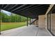 Spacious covered patio featuring concrete flooring and views of the lush backyard with stairs to the upper deck at 1255 E M Croy Rd, Sugar Hill, GA 30518