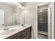Well-lit bathroom with dual sinks, wood cabinets, and tiled walk-in shower at 1370 Dupont Nw Park, Atlanta, GA 30318