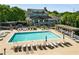 A community pool with multiple lounge chairs around the pool with a clubhouse and landscaping in the background at 1370 Dupont Nw Park, Atlanta, GA 30318