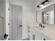 Elegant bathroom with white vanity, black hardware, and stylish lighting fixture above the mirror at 4281 Sierra Creek Ct, Hoschton, GA 30548