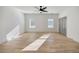Light filled bedroom with wood floors, two windows, ceiling fan and light gray door at 4281 Sierra Creek Ct, Hoschton, GA 30548