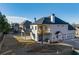 View of the rear exterior featuring a balcony, outdoor kitchen area, and a three-car garage at 4281 Sierra Creek Ct, Hoschton, GA 30548