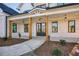Welcoming covered porch with timber columns, pendant lights, and a stylish double-door entrance at 4281 Sierra Creek Ct, Hoschton, GA 30548