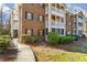 A brick apartment building with black shutters and white railings, with a green lawn and sidewalk at 706 Barrington Hills Dr, Atlanta, GA 30350