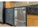Kitchen features stainless steel dishwasher drawer under granite countertops and wooden cabinets at 706 Barrington Hills Dr, Atlanta, GA 30350
