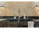 Farmhouse sink with stainless steel fixtures and neutral tile backsplash create a charming and functional kitchen space at 706 Barrington Hills Dr, Atlanta, GA 30350