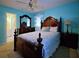 Bright bedroom featuring a wooden bed frame, a matching dresser, and blue accent wall at 5235 Pounds S Dr, Stone Mountain, GA 30087