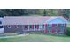 Charming brick home featuring red shutters, a covered porch, and a sprawling front lawn in a desirable neighborhood at 5235 Pounds S Dr, Stone Mountain, GA 30087