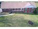 Well-maintained brick home with red shutters, a spacious front yard, and a welcoming covered porch with columns at 5235 Pounds S Dr, Stone Mountain, GA 30087