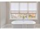 Modern bathtub under a bright window provides a luxurious feel to this bathroom at 574 Boulevard Ne Pl # 14, Atlanta, GA 30308