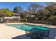 Community pool, patio, and seating with lush green trees in the background at 2516 Bradford Ne Sq, Atlanta, GA 30345