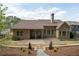 View of backyard that has a covered patio, wooden deck, and landscaped area surrounded by tall trees at 65 Turtle Rock Cv, Acworth, GA 30101