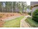 Spacious backyard featuring wooded views, retaining wall, and stone pathway at 65 Turtle Rock Cv, Acworth, GA 30101