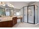 Bright bathroom with granite countertop vanity, decorative mirrors, and tiled floor adjacent to a glass enclosed walk-in shower at 65 Turtle Rock Cv, Acworth, GA 30101