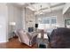 Cozy living room with stone fireplace, ceiling fan, and multiple windows at 65 Turtle Rock Cv, Acworth, GA 30101