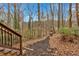 Scenic backyard featuring mulched path leading toward a wooded area with stairs leading up to deck at 931 Cornwall Sw Ct, Marietta, GA 30064