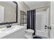 Bathroom featuring a white vanity, toilet, black shelving, and a shower-tub combination with a shower curtain at 931 Cornwall Sw Ct, Marietta, GA 30064