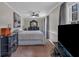 Main bedroom with dark wood dressers, neutral carpet, lighted ceiling fan, and bright window overlooking outdoors at 931 Cornwall Sw Ct, Marietta, GA 30064
