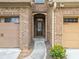 Close-up of front entryway showcasing brick detail, arched doorway and access to garages at 2105 Caswell Cir, Marietta, GA 30060