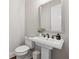 Elegant powder room features a pedestal sink, modern fixtures, and a decorative mirror at 6682 Sterling Dr, Atlanta, GA 30328