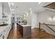 Spacious kitchen with white cabinets, dark island, stainless appliances, and hardwood floors, open to living area at 6682 Sterling Dr, Atlanta, GA 30328