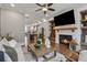 Inviting living room with a cozy fireplace, mounted TV, hardwood flooring, and views of an open-concept kitchen area at 6682 Sterling Dr, Atlanta, GA 30328