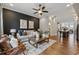 Well lit living room featuring hardwood floors, modern decor, and an open layout leading into the dining and kitchen area at 6682 Sterling Dr, Atlanta, GA 30328