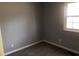 This bedroom features neutral gray walls, carpet flooring, a window for natural light, and essential electrical outlets at 6831 Lismore Dr, Norcross, GA 30093