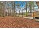 A spacious backyard featuring a wooded area, small deck, and a storage shed at 12 Remington Ct, Euharlee, GA 30145