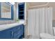 Bathroom featuring blue vanity, mirror, and fixtures plus a shower with curtain at 12 Remington Ct, Euharlee, GA 30145