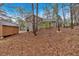 Exterior view of the back of the house showing a wooden storage shed and wooded backyard at 12 Remington Ct, Euharlee, GA 30145