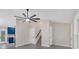 Open-concept living space with ceiling fan, stairs, and entrance to kitchen at 12 Remington Ct, Euharlee, GA 30145