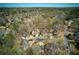 A high-angle aerial shows the home nestled in a wooded suburban neighborhood at 210 Chiswick Close, Johns Creek, GA 30022